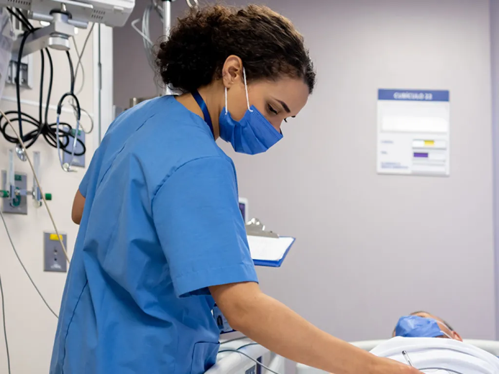 Enfermera en una unidad de cuidados intensivos, supervisando a un paciente